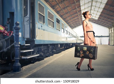 fair traveler with vintage suitcase at the station