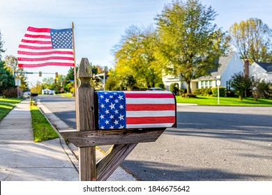 Fairfax County in northern Virginia with patriotic mailbox on election year with stars stripes design and American flag waving in wind by street road in neighborhood