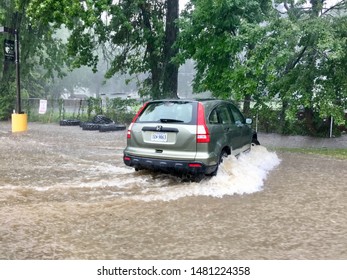 Fairfax, Virginia, USA - August 15, 2019: A Honda CRV Is Deluged By Powerful Flood Waters In A Paul VI Catholic High School Parking Lot Caused By An Inundation Of Rain.