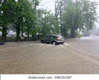 Fairfax, Virginia, USA - August 15, 2019: Flood waters rush down a Paul VI Catholic High School parking lot during a short but powerful storm that inundated the area with a deluge of rain.