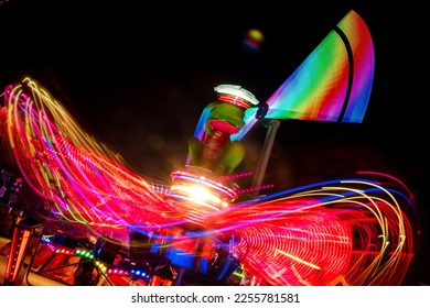Fairground rides at nighttime with stunning light trails and intentional  blurry out of focus motion.