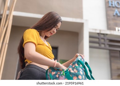 A Fair-skinned Asian Woman Checks Her Bag Before Going Out To Run Some Errands. Being Forgetful And Absentminded.