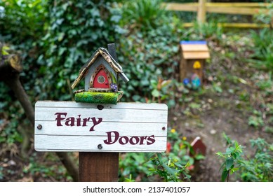 Fairy Doors wooden sign post with fairy houses in outdoor enchanted fairy garden in Ireland. 