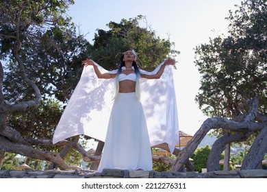 A Fairy Girl Lifting Her White Cloak To The Sky With Her Arms.