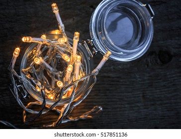 Fairy Lights In A Glass Jar On Dark Wooden Table