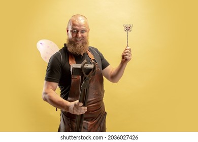 Fairy man. Comic image of bearded bald man, blacksmith leather apron or uniform isolated on yellow background. Concept of labor, retro professions, beauty, humor. Funny meme emotion