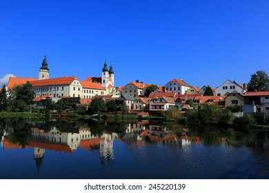 A fairy tale castle and old town with beautiful lakeside reflection on smooth water under clear blue sky in Telc, Czech Republic, Europe ~ A UNESCO world heritage city