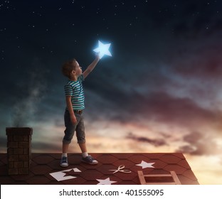 Fairy Tale! The Child Hanging The Stars In The Sky. Boy On The Roof Cuts Out Stars.