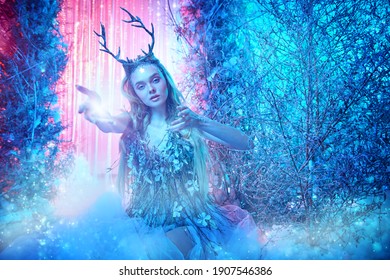 Fairy world. Beautiful forest nymph in a magical winter forest covered with snow. 
