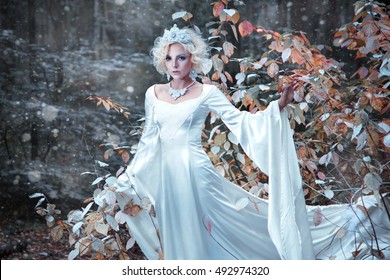Fairytale Snow Queen portrait bringing winter in autumn forest.
