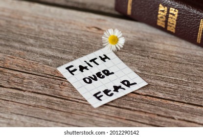 Faith over fear. Inspiring handwritten quote from the Bible Book. Trust, faith, hope, belief in God and Jesus Christ. Devoted faithful Christian biblical concept. A closeup.