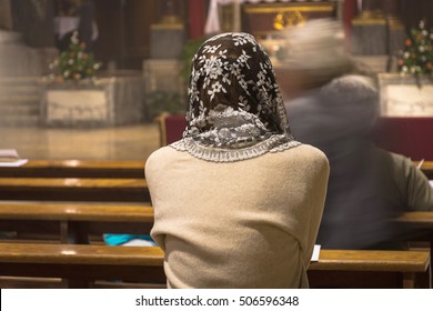Faithful woman with head lace veil during the traditional latin catholic mass