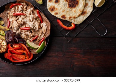 Fajita with pulled pork and bell peppers. Tortillas, grilled avocado, onions  served with meat and vegetables on plate. Tex-mex cuisine