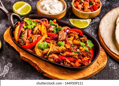 FAJITAS with colored pepper and onions, served with tortillas, salsa and sour cream.