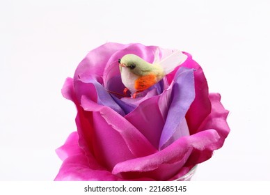 A Fake Bird And Purple Textile Rose Flower 