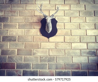 Fake Deer Head Hangs On The Brick Wall