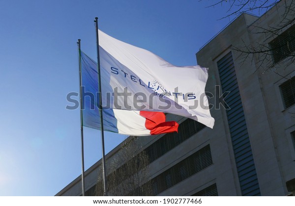 Fake French flag and Stellantis corporation flag at\
italian headquarters after merging between Groupe PSA and FCA\
automotive representing the actual stakeholder control Turin Italy\
January 25 2021