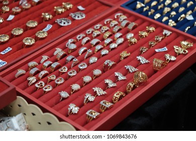 Fake gold and silver rings storage box in a number of rows selling in a market in Thai rural area.