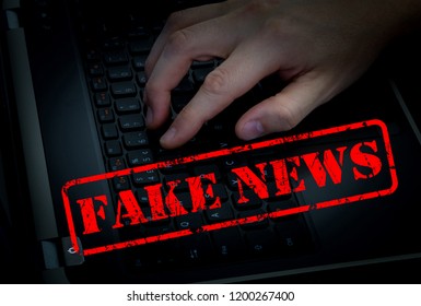 Fake news with male hand on keyboard in dark room background. Conceptual image for social network.