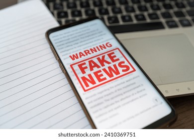 A Fake news warning notification appearing on the phone while in use. Concept of information manipulation.