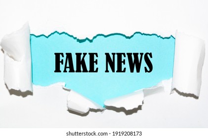 FAKE NEWS word written under torn paper. - Shutterstock ID 1919208173
