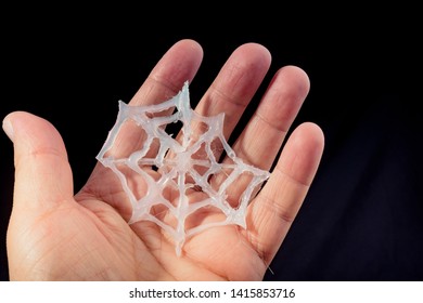 Fake Spider Web Found In Hand On Black Background