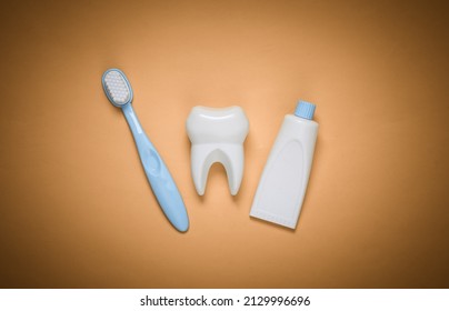 Fake tooth, toothbrush and toothpaste on yellow background. Top view - Powered by Shutterstock