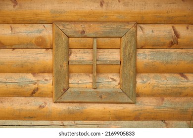 Fake window frame on the background of wooden logs