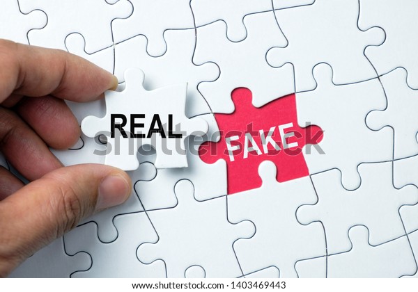 Fake word on missing puzzle with a hand hold a\
piece of real word puzzle