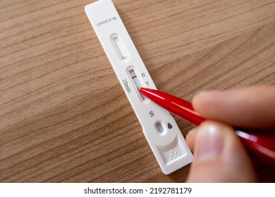 Faking A Negative Covid Antigen Test To Make It Positive. Drawing A Line For The T Indicator. Skip Work With A Positive Covid Test Because Of Stress And Burnout. Holding A Red Pen Over A Specimen.