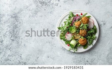 Falafel and vegetables salad on a white ceramic plate on concrete background, top view, copy space Stock photo © 