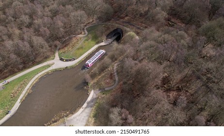 Falkirk, Scotland, UK; 26th March 2022: Aerial image of a barge entering the tunnel of the Union Canal near the Falkirk Wheel, a unique rotating boat-lift.