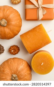 Fall background. Pumpkins and handcrafted candles create a delightful autumn display.