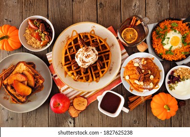 Fall Breakfast Or Brunch Buffet Table Scene Against A Dark Wood Background. Pumpkin Spice, Waffles, Pancakes, Apple French Toast, Oatmeal, Egg Skillet, Yogurt. Top Down View.