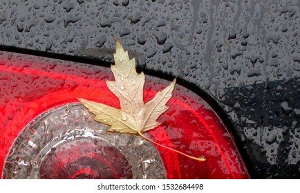 Fall Car Care. Tail Light, Raindrops And Fallen Leaf Closeup On A Car Surface  Background 