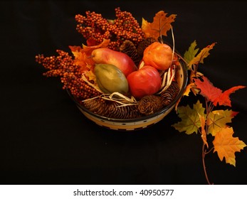 Fall Centerpiece With Foliage And Fruit Shown On A Black Background