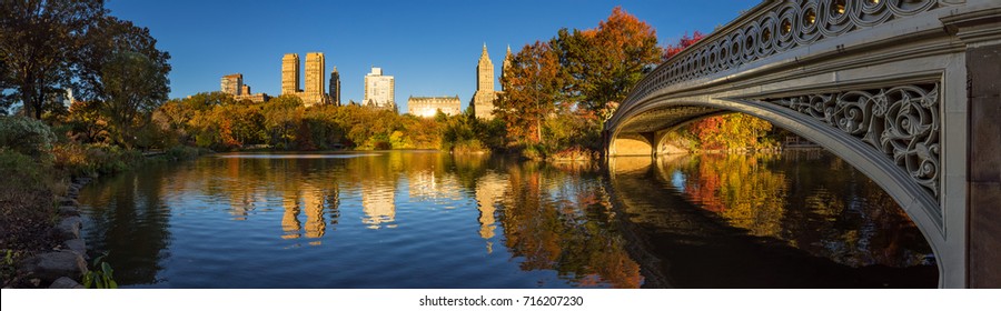 Fall in Central Park at The Lake with the Bow Bridge. Panoramic morning view with colorful autumn foliage on the Upper West Side. Manhattan, New York City - Shutterstock ID 716207230