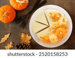 Fall cheesecake dessert with delicious pumpkin cheese balls. Top down view table scene on a dark stone background.