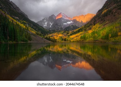 Fall color of aspen forest at Maroon Bells, Colorado. Beautiful sunrise with reflection lake. - Shutterstock ID 2044674548
