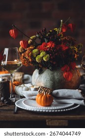 Fall composition. Orange pumpkins, flowers and candles on wooden table. Family elegant Thanksgiving or halloween dinner. Cozy autumn concept, simple handmade decoration, countryside style, wine