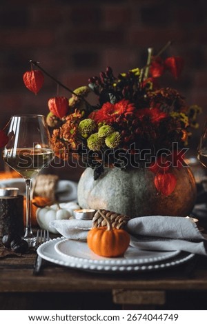 Fall composition. Orange pumpkins, flowers and candles on wooden table. Family elegant Thanksgiving or halloween dinner. Cozy autumn concept, simple handmade decoration, countryside style, wine