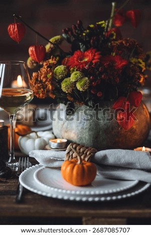 Fall composition. Orange pumpkins, flowers and candles on wooden table. Family elegant Thanksgiving or halloween dinner. Cozy autumn concept, simple handmade decoration, countryside style, wine