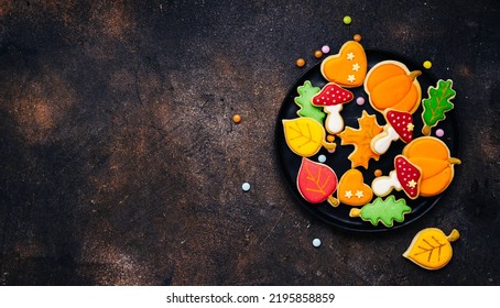Fall cookies table scene with a mixture of sweet autumn treats. Dark brown background with copy space. Top view - Shutterstock ID 2195858859