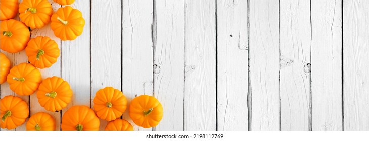 Fall Corner Border Of Orange Pumpkins Over A White Wood Banner Background. Above View With Copy Space.