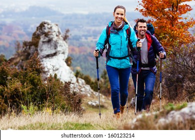 Fall. Couple Backpackers hiking on the path in mountains during autumn.