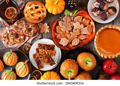 Fall Desserts Table Scene With A Mixture Of Sweet Autumn Treats. Top Down View Over A Dark Wood Background.