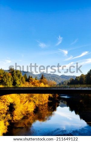 Fall foliage colors and a brilliant blue sky reflected in the scenic Russian River, Sonoma County, Northern California. Copy space for text.
