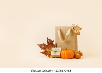 Fall Gift or Sale concept. Shopping paper bag, with golden maple leaves and pumpkins. autumn decor. Thanksgiving. Copy space - Powered by Shutterstock