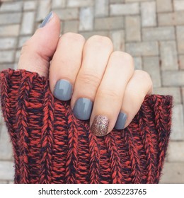 Fall Manicure With Sweater And A Stone Background.