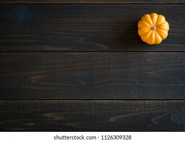 Fall Mini Pumpkin In Minimalist Still Life Card On Moody, Dark Shiplap Wood Boards With Extra Room Or Space For Copy, Text Or Your Words.  Horizontal Photo From Above With Trendy Flat Layout View